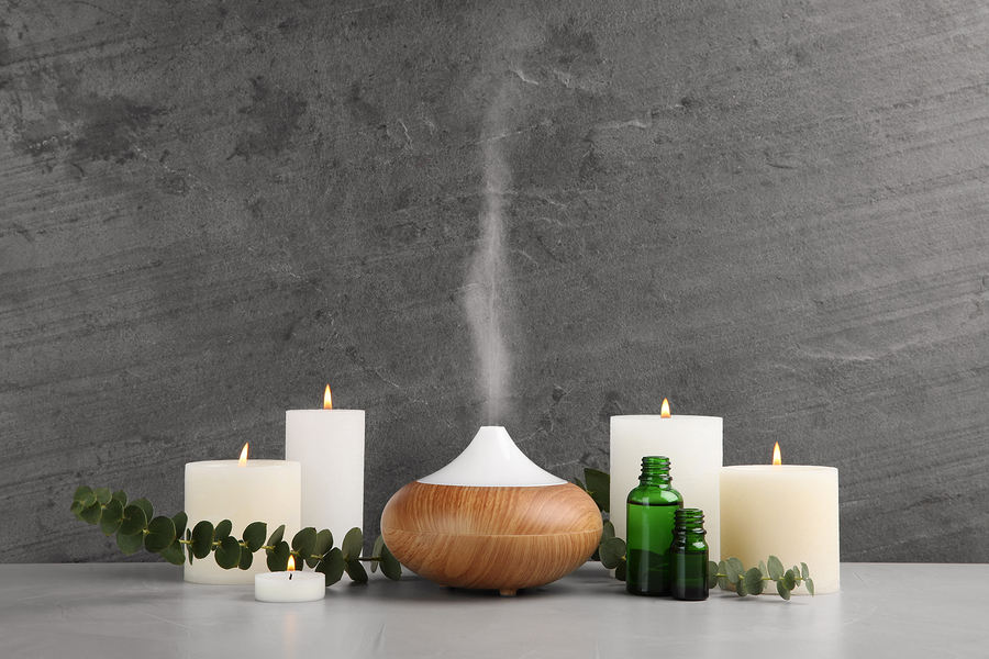 Composition with essential oils diffuser on table against grey background